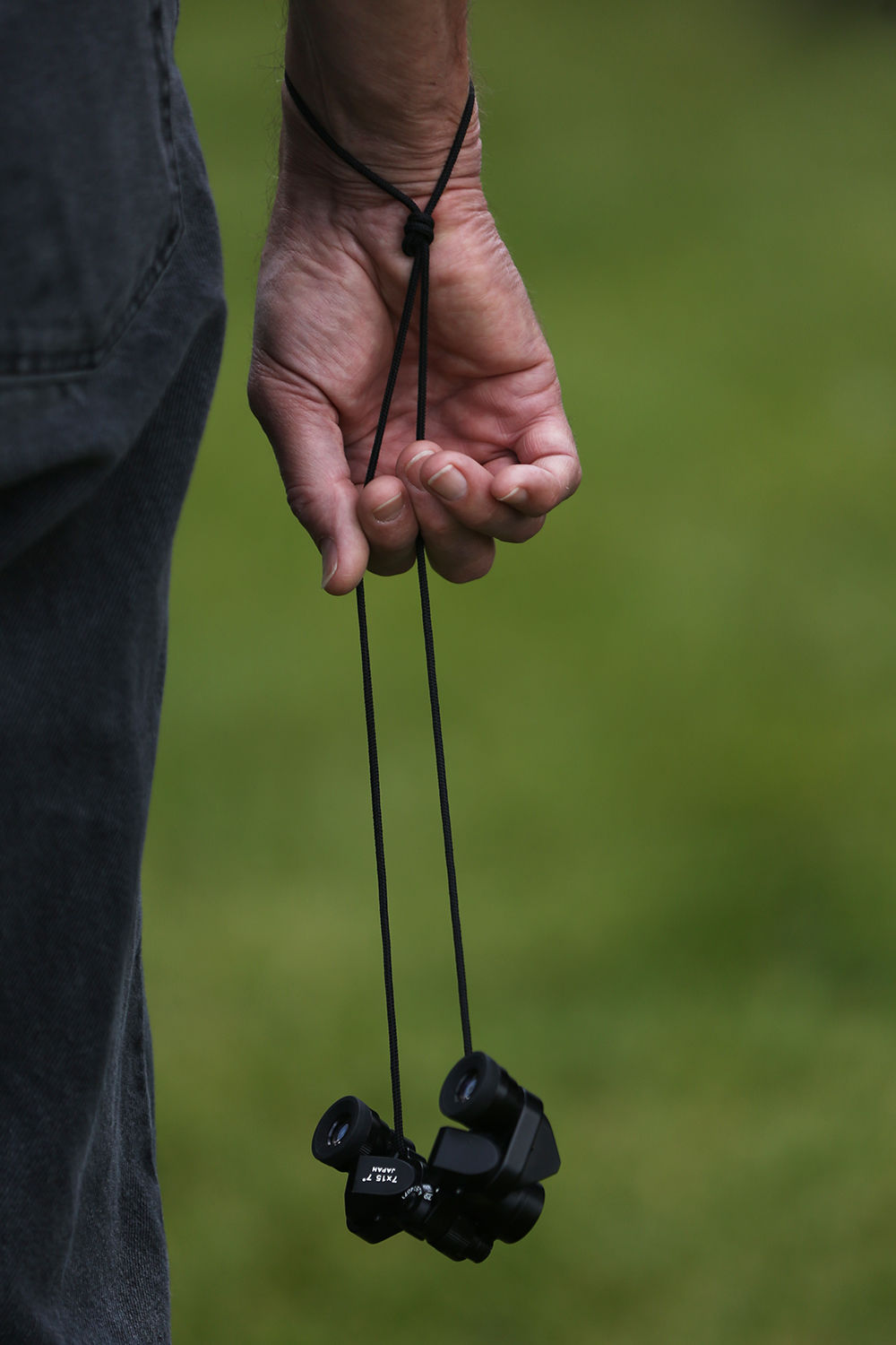 Rich Urbatchka holds a smaller pair of binoculars on his wrist